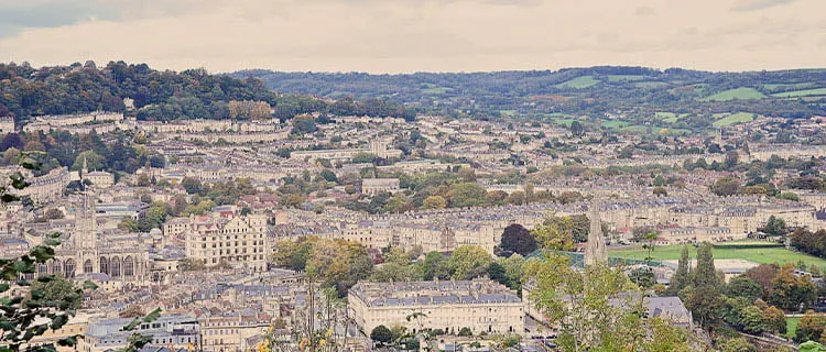 Landscape view of Bath city centre from a high vantage point showing all the city, including Bath Abbey and countryside in the distance