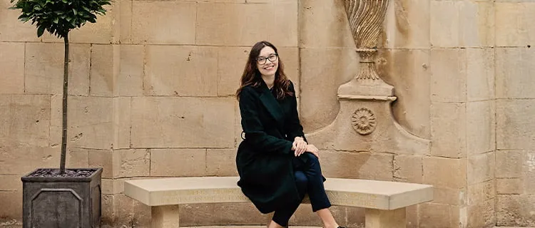 Mortgage team employee sat on bench outside of building.