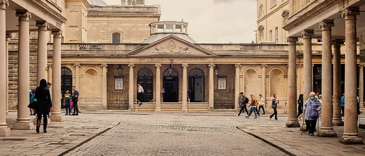 Landscape image of Bath city Centre showing roman bath spa and typical Bath stone buildings.