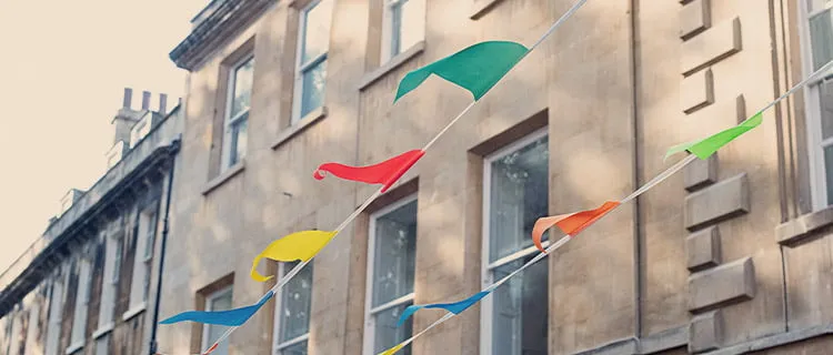 Landscape image of bunting across a background of typical bath stone buildings in the background.