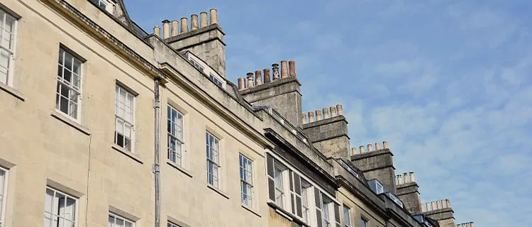 Landscape image of top floor of row of terraced residential houses and the sky