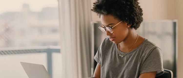 Landscape of woman sat at laptop working from home.