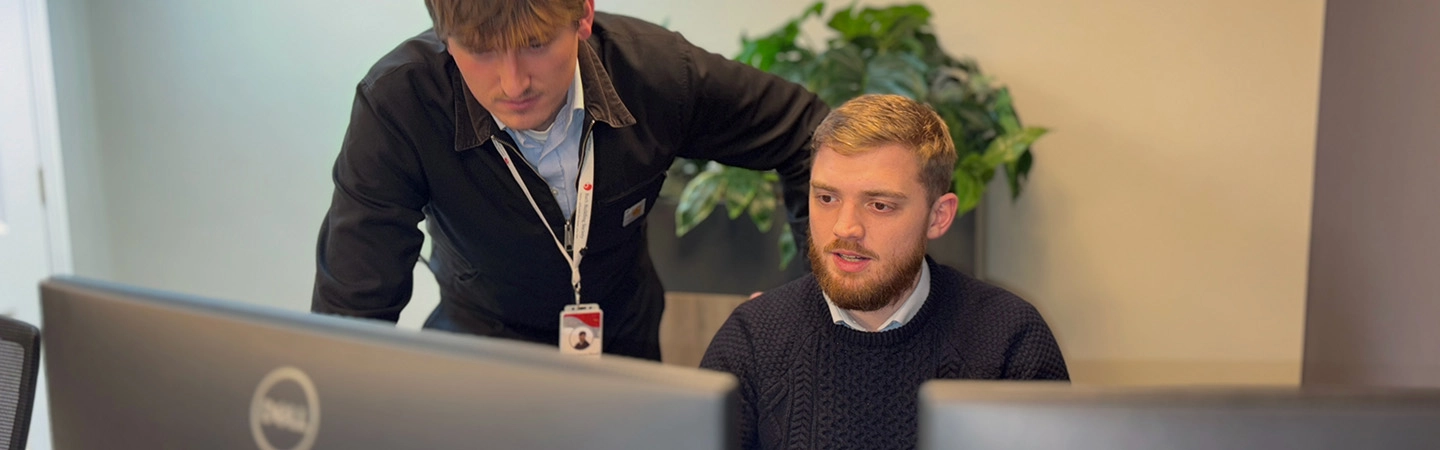 Colleagues talking at a desk